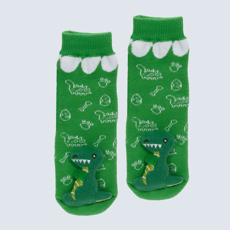 Green baby socks against a white background. The socks feature embroidered dino motifs and two large dinosaur plushes on the toe.