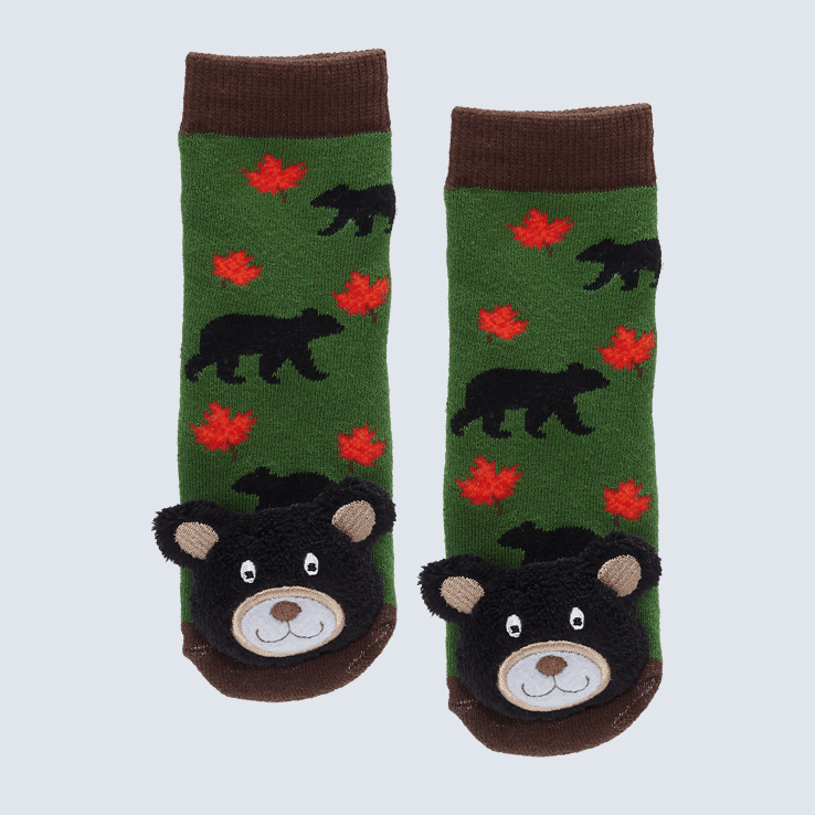 Two green and brown socks against a white background. The socks feature a red maple lead motif and a cute plush bear charm on the toe.
