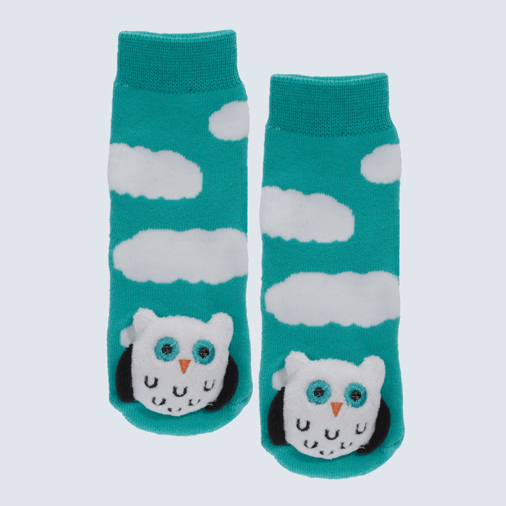 Blue-green baby socks against a white background. The socks feature cloud motifs and a large owl plush on the toe.