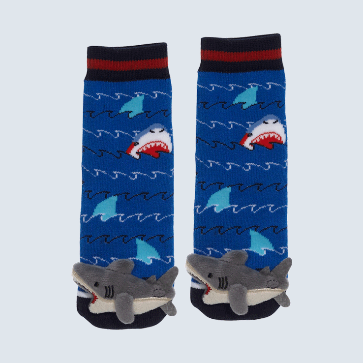 Two shark socks against a white background. The socks feature a sea, shark, and fin motif. Each sock has a cute plush shark charm on the toe.